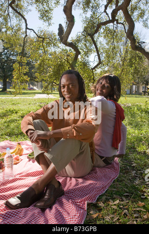 African American giovane avente un picnic all'aperto nel parco Foto Stock