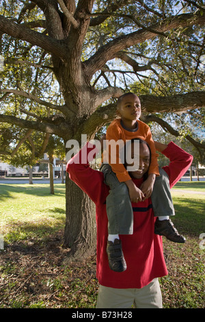 African American padre figlio di contenimento sulle spalle in posizione di parcheggio Foto Stock