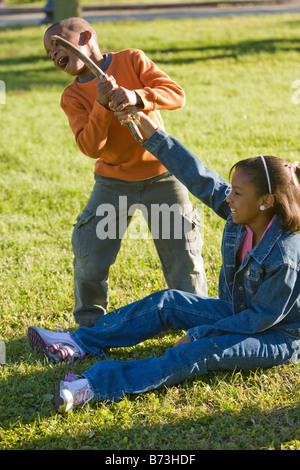 Americano africano un ragazzo e una ragazza a giocare all'aperto nel parco Foto Stock