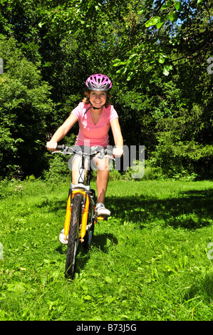 Ritratto di una ragazza adolescente in bicicletta nel parco estivo all'aperto Foto Stock