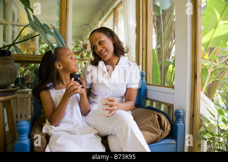 Felice afro-americano di madre e figlia in veranda a parlare Foto Stock