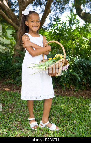 Carina ragazza afro-americano tenendo cesto fiorito Foto Stock