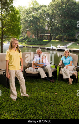 Famiglia di quattro seduti in cortile con vista sul lago Foto Stock
