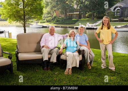 Famiglia di quattro seduti in cortile con vista sul lago Foto Stock