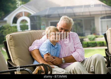 Nonno con figlio seduti insieme in cortile Foto Stock