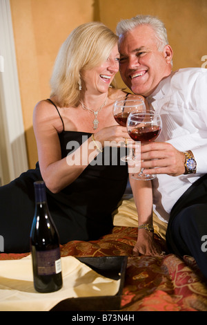 Romantica di mezza età matura in abbigliamento formale di bere vino in camera da letto Foto Stock