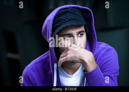 Close-up del giovane serio indossando felpa con cappuccio di colore viola Foto Stock