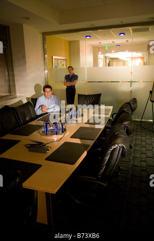 Due multi-razziale gli imprenditori in sala riunioni di notte lavora fino a tardi Foto Stock