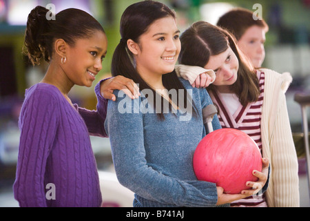 Multi-etnico ragazze con palla da bowling a bowling Foto Stock