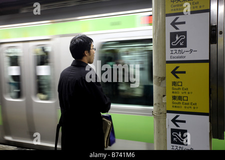 Un passeggero vi aspetta per il treno alla fermata sulla piattaforma presso la stazione JR di Shinagawa stazione ferroviaria sulla Linea Yamanote Foto Stock