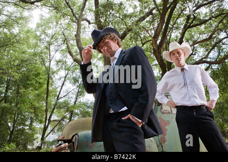 Due giovani cowboy standing vicino vintage carrello all'aperto Foto Stock