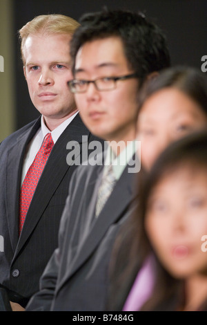 Imprenditore caucasico con gruppo di dirigenti asiatici Foto Stock