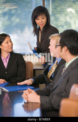 Imprenditore caucasico incontro con un gruppo di dirigenti asiatici in sala riunioni Foto Stock