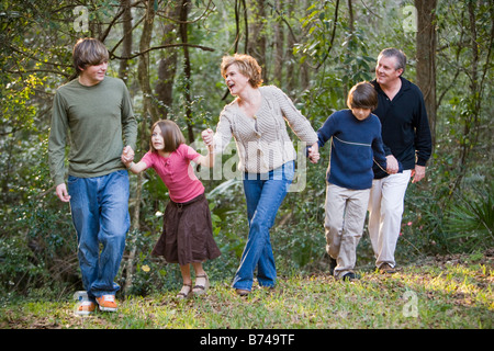 Ritratto di famiglia tenendo le mani lungo il bordo della foresta Foto Stock