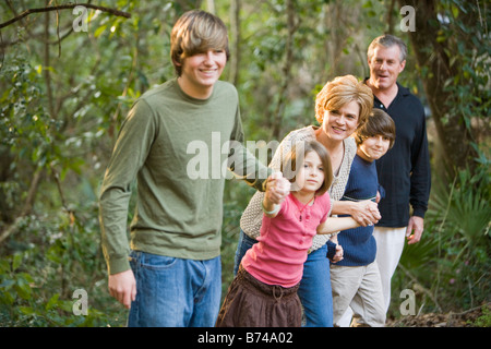 Led di famiglia dal figlio adolescente holding hands passeggiate all'aperto da boschi Foto Stock