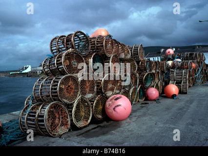 Lobster Pot fatti dal vimini e materiale naturale alta impilati su un litorale atlantico pier Foto Stock