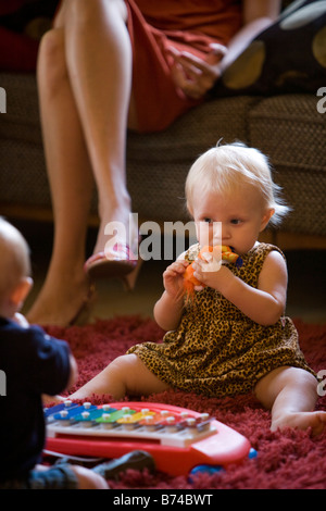 Baby sitting su rug giocando Foto Stock