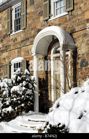 Coperta di neve entrata di pietra costruito house Foto Stock