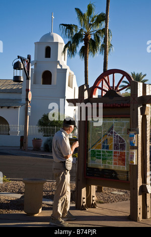 Uomo che guarda la mappa. La Città Vecchia di Scottsdale con stile Adobe la Madonna del Perpetuo Soccorso chiesa della Missione in background Arizona USA Foto Stock