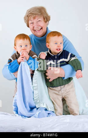 Nonna felice con redheaded nipoti con coperta Foto Stock