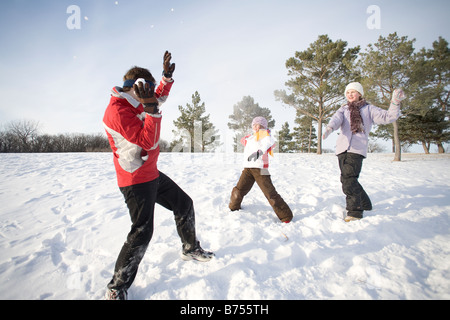 3 bambini (14, 13, e 9) gettare neve a ciascun altro, Winnipeg, Canada Foto Stock