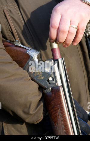 Una pistola carica il suo foro 12 fucile con una cartuccia durante un gioco shoot Foto Stock