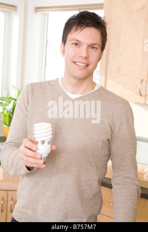 L'uomo azienda efficiente di energia fluorescente compatta lampadina, Winnipeg, Canada Foto Stock