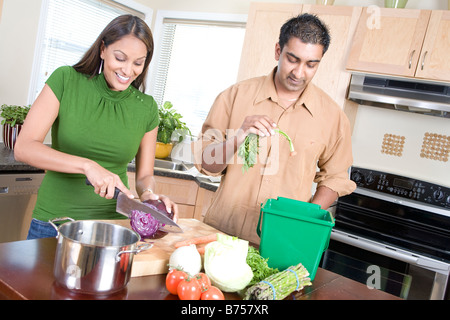 Matura in cucina il taglio di vegetali accanto alla cucina compost bin, Winnipeg, Canada Foto Stock