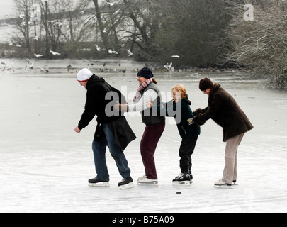 Le famiglie possono usufruire divertirsi sul ghiaccio al ghiacciato Falmer stagno vicino Brighton Regno Unito Foto Stock