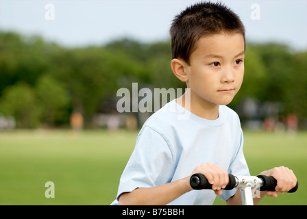 Bambino di otto anni su scooter, Winnipeg, Manitoba, Canada Foto Stock