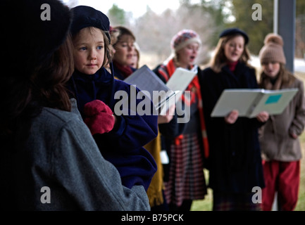Gruppo di persone a cantare i canti natalizi alla storica Rugby, Tennessee. Foto Stock