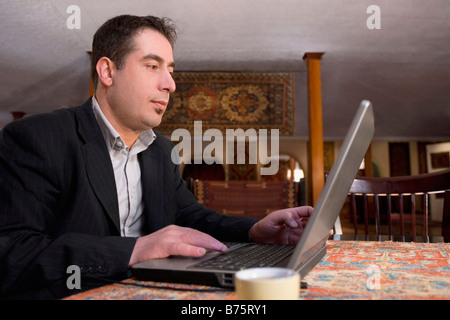 Imprenditore lavora su un computer portatile in un ristorante Foto Stock