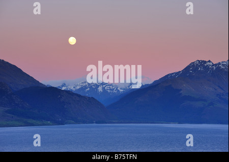 Luna sul lago Wakatipu all'alba, vicino a Queenstown guardando verso Glenorchy e Fiordland, Nuova Zelanda Isola del Sud Foto Stock