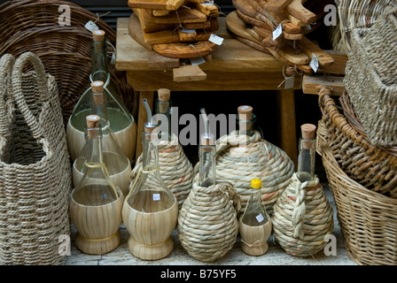 Artigiano autentico vetro di bottiglie di vino e cesti di vimini fatti a mano sul display in stile country, mercato all'aperto. Foto Stock