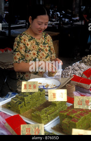 1, una donna cinese, donna musulmana, musulmana, venditore ambulante, vendono dolci, candy, caramelle, il Quartiere Musulmano, città, Xian, Provincia di Shaanxi, Cina Foto Stock