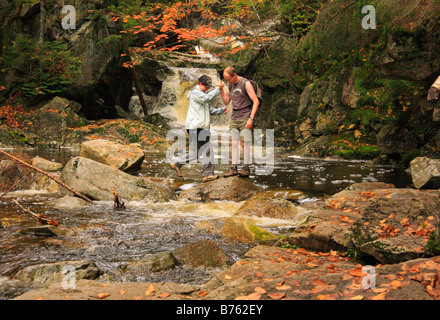 Gli escursionisti Cross cascata Brook sul sentiero Cascades-Basin, Appalachain Trail, Lincoln, New Hampshire, STATI UNITI D'AMERICA Foto Stock