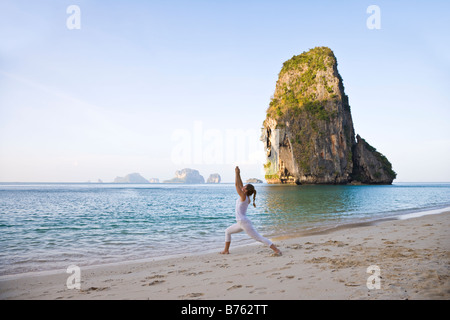 La donna a praticare lo yoga e la spiaggia Foto Stock