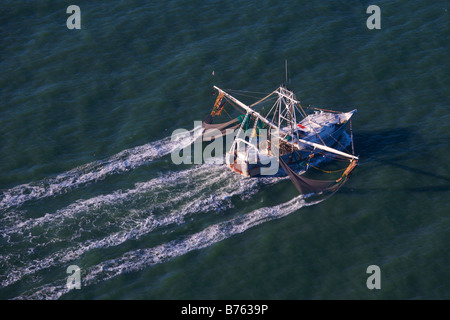 Vista aerea di una barca da gamberetti reti di lavoro interrotta l'acqua al largo di Charleston nella Carolina del Sud Foto Stock