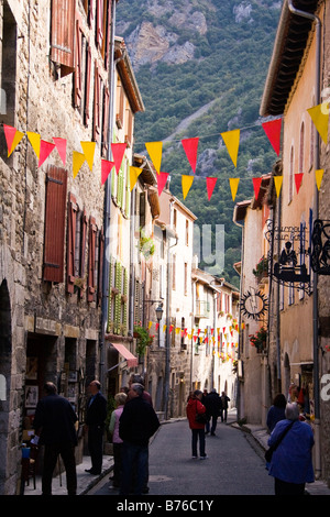 Strada di Villefranche con tipiche facciate e le montagne sullo sfondo Foto Stock