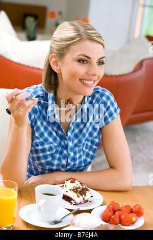 Frau isst ein Stueck Torte, donna di mangiare una fetta di torta Foto Stock