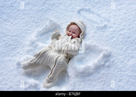 Una bambina nella neve, apparentemente avendo realizzato un angelo di neve pattern. Foto Stock