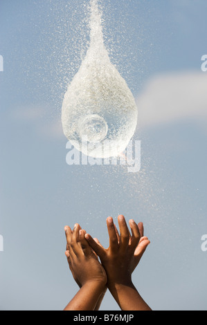 Indian boys cattura una raffica di palloncino dell'acqua. India Foto Stock