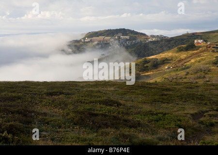 Il Cloud si insinua nel corso del vertice e Villaggio di Mt Hotham Foto Stock