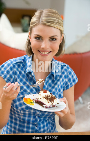 Frau isst ein Stueck Torte, donna di mangiare una fetta di torta Foto Stock