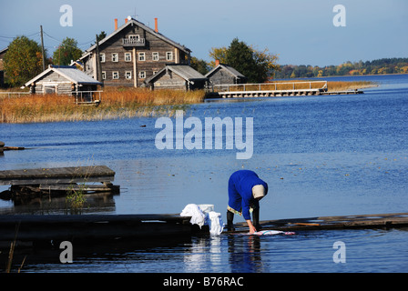 Una vecchia signora il lavaggio della biancheria nel lago Onego, isola di Kizhi, Carelia Foto Stock