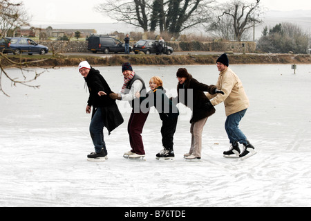 Le famiglie possono usufruire divertirsi sul ghiaccio al ghiacciato Falmer stagno vicino Brighton Regno Unito Foto Stock