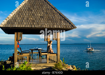 Bordo d'acqua rifugio al tramonto, Shangri-La Island Resort & Spa, Mactan Island, Cebu, Visayas, Filippine Foto Stock