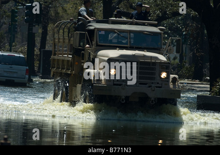 Veicolo militare schizzi attraverso le profonde acqua di inondazione con militare di mantenimento della pace per il personale di bordo di New Orleans Foto Stock