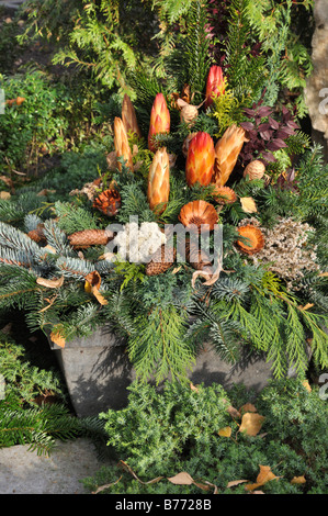 Grave decorazione con rami di abete, coni e fiori secchi Foto Stock