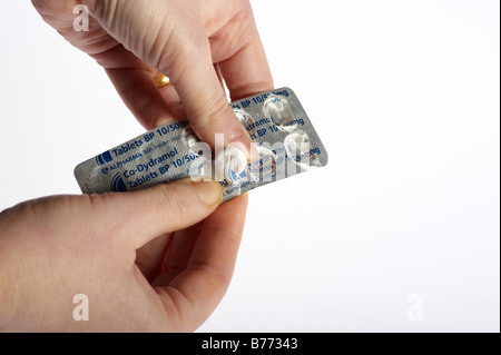 La donna la foratura di tablet farmaci antidolorifico dalla striscia di compresse Foto Stock